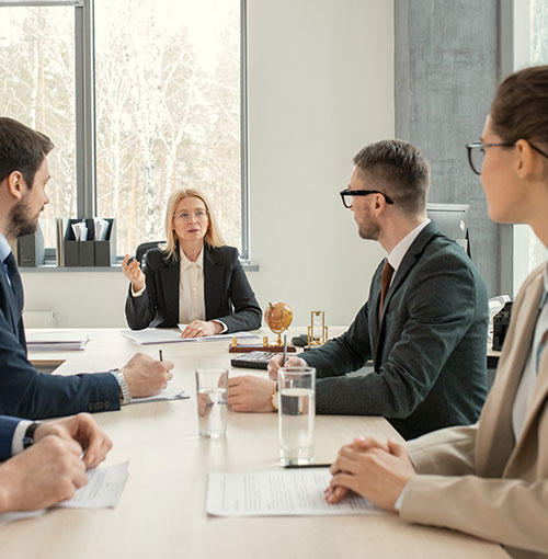 Empresários discutindo contratos comerciais e práticas de compliance em ambiente corporativo com apoio da equipa da Lopes & Campos Advogados Associados.